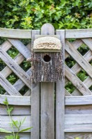 Bird house outside hung on a fence