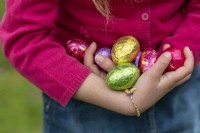 Child holding colourful chocolate eggs at Easter
