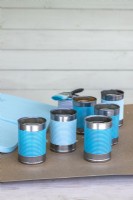 Painted blue tin cans and wooden boards prior to assembly