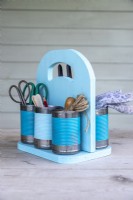 Finished pastel tin can caddy containing gardening tools and supplies