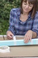 Woman placing masking tape on the wooden post