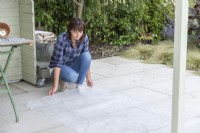 Woman placing plastic sheet on the ground to catch any loose compost