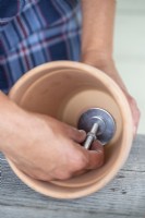 Screwing a nut onto the steel rod inside the pot