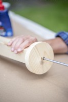 Screwing wooden disc onto the end of the post