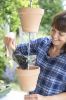 Woman filling pots with compost