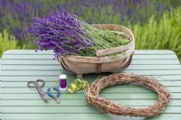 Lavender, wire, wire cutters, wreath, garden scissors and cord laid out on a table