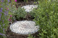 Mosaic stepping stones placed among plants