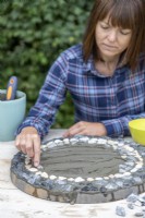 Woman placing pebbles on the grout