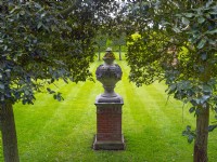Urn on plinth Green Court garden at East Ruston Old Vicarage, Norfolk April