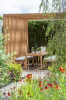 Outdoor dining area with natural wood pergola - The Viking Friluftsliv Garden - RHS Hampton Court Festival 2021