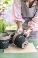 Writing plant names on the pots wiith a chalk pen