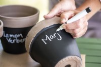 Writing plant names on the pots with a chalk pen