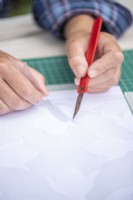 Cutting the stencil out of the plastic sheet with a craft knife
