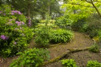 A path edged with logs through the Wilderness Garden.