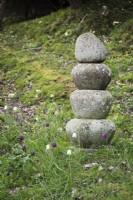 Stone feature surrounded by naturalised snake's head fritillaries at Lower House, Powys in March