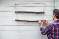 Tying sash cord around hazel sticks