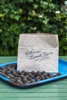 Finished seed bombs around a brown paper bag