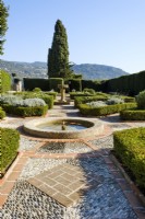 Parterre with clipped box and grey foliage plants. Central circular fountains with brick and inlaid pebble paving, with hedge to the side and end. Garden of the Cimiez Monastery, Jardin du Monastere de Cimiez,  Nice.