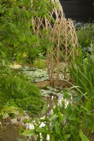 Laminated bamboo grid structures in a pool surrounded by aquatic plants including Nymphaea and Pontederia cordata  the Guangzhou China: Guangzhou Garden, winner of the best show garden.