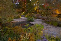 The M and G Garden, a shared urban space with judiciously placed lighting accentuating the warm colours of the autumnal plantings surrounding a small pool.