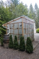 Greenhouse made from recycled glass bottles. Rainwater collection system for interior misting
