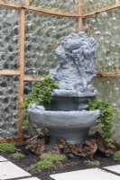 Fountain inside greenhhouse made from recycles glass bottles provides humidity