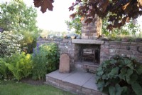Stone fireplace built as a feature in cottage garden