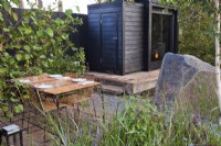 Outdoor dining area and a sauna. Finnish Soul Garden at Chelsea Flower Show 2021 