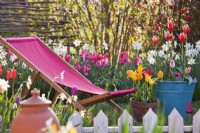Deck chair and containers planted with tulips.
