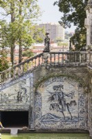 Stone staircase at the side of the Basin of the Knights. Walls faced with glazed tiles or Azulejos. View beyond garden to the city. Lisbon, Portugal, September.