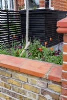 Front garden with low brick wall and sloping coping