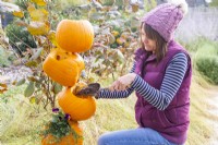 Woman adding compost to the pumpkins