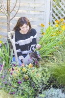 Woman removing Crocosmia from pot