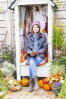Woman sitting outside in Autumnal setting reading magazine