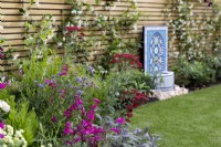 Mixed summer border in contemporary suburban garden 