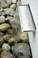 Small waterfall incorporated into low dividing wall.