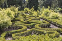 View over the Old Labyrinth Garden. Low hedges of clipped Box with planting of pomegranate fruit tees in beds within hedges. Queluz, Lisbon, Portugal, September. 