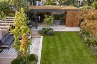 Aerial view of contemporary suburban garden with pergola and garden room or office with Acer rufinerve in foreground