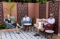Couple relaxing with their daughter in their Moroccan style patio garden 