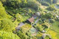 View over whole garden with house in the centre ;image taken with drone. Formal hedges of Yew. July. Summer.