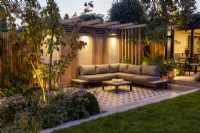 Modern garden patio and pergola at night with lighting