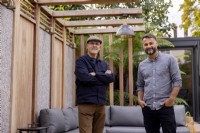 Designers Nick Gough and Douglas Vieira standing in a contemporary garden they have designed
