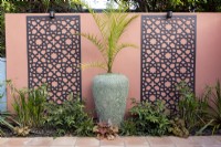 Phoenix Palm against brightly coloured wall with decorative screens