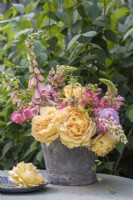 Apricot roses and Digitalis arranged in metal bucket with lupins