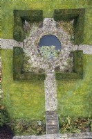Aerial view of a circular pond inside a square of yew hedges in a formal garden