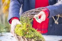 Woman using wire to secure moss to the wreath