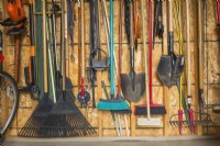 Stored assorted gardening tools on wall of garden shed, Quebec, Canada