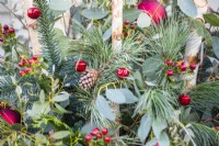 Pine cone and baubles in an evergreen Christmas container
