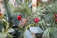 Pine cone and baubles in an evergreen Christmas container