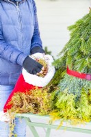 Woman stuffing the hat with moss
